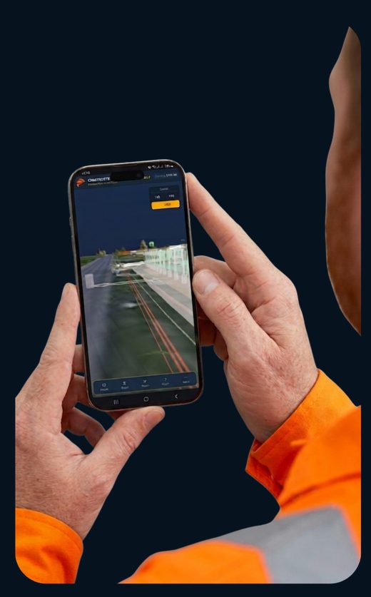 A site operative in hi-vis holding a phone showing existing buried services on the model